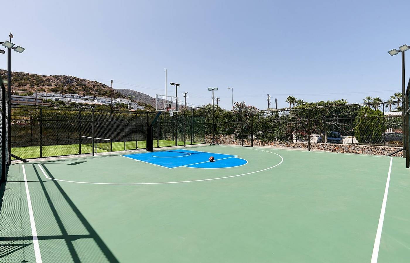 Basketballplatz am Arminda Hotel & Spa mit umzäuntem Bereich und grünem Spielfeld.