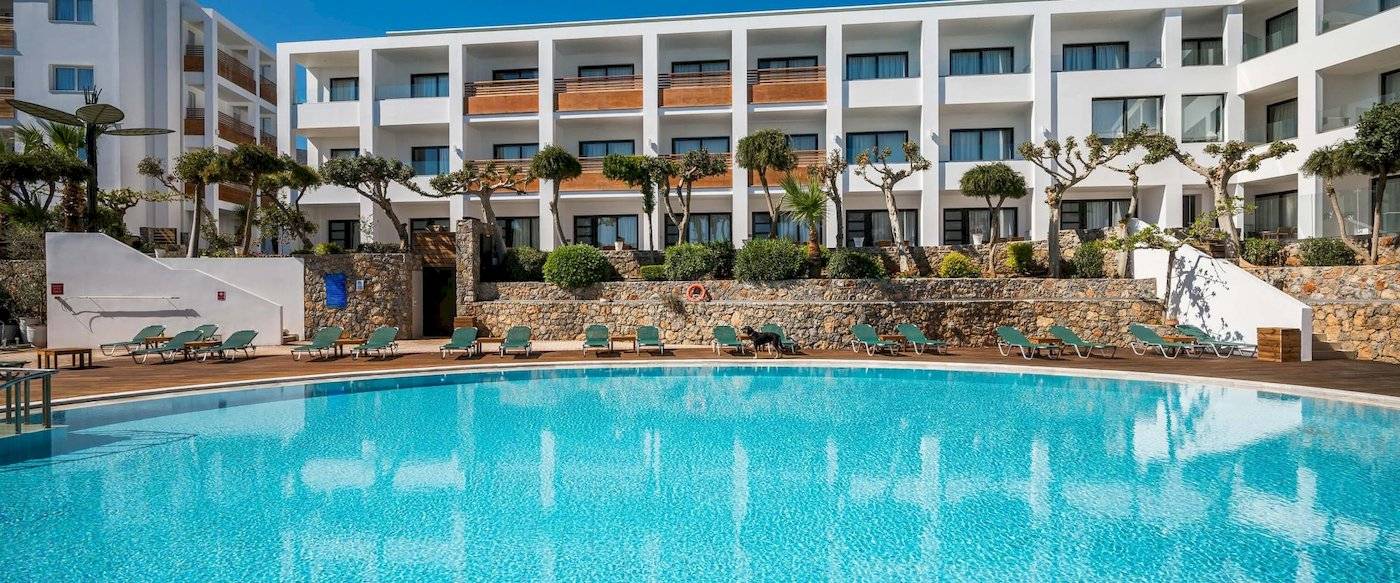 Arminda Hotel & Spa mit Pool und Liegen vor der Hotelanlage