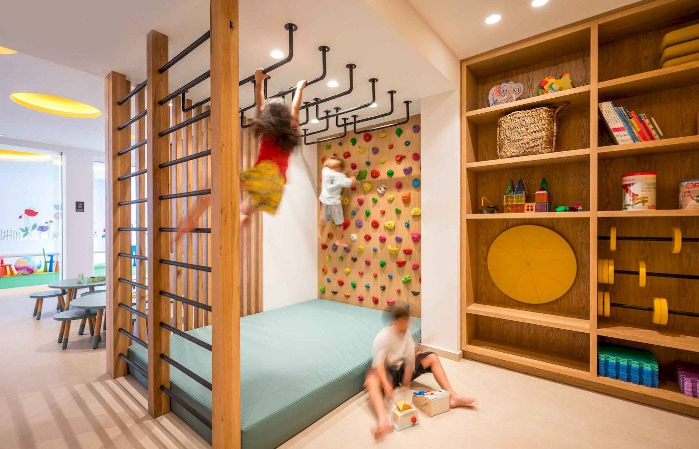 Im Arminda Hotel & Spa befindet sich ein Kinderzimmer mit einer Kletterwand und Spielzeug.