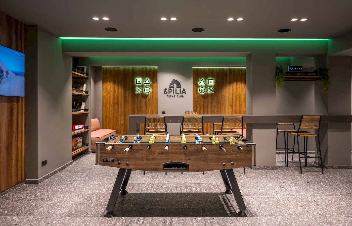 Arminda Hotel & Spa Spilia Teens Club mit Tischfußball, Holztüren und grüner Beleuchtung.