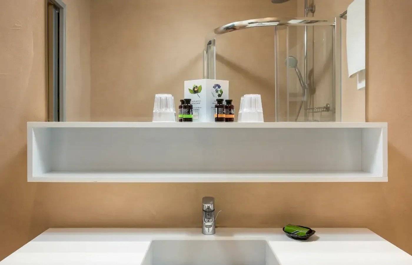 Badezimmer im Corissia Beach Hotel mit Dusche und Waschbecken.