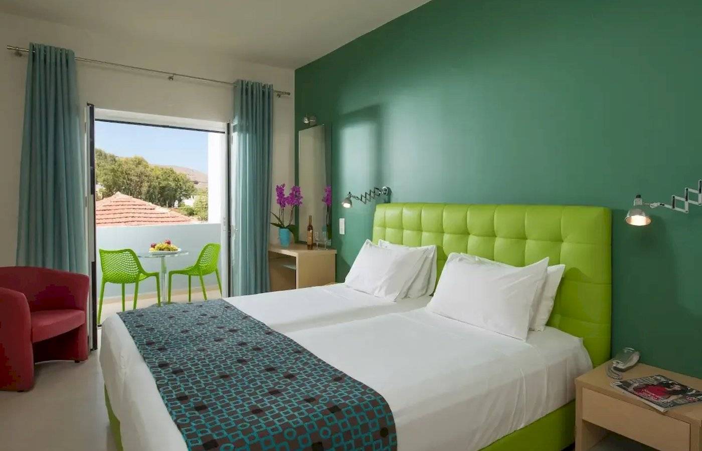 Doppelzimmer im Corissia Beach Hotel mit grüner Wand und Balkon.