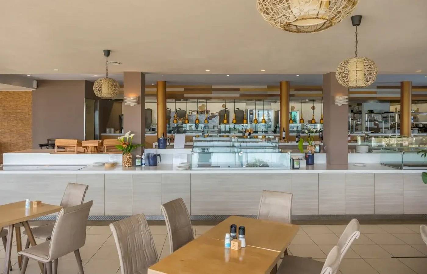 Innenansicht des Corissia Beach Hotel Restaurants mit Tischen, Stühlen und einer Theke.