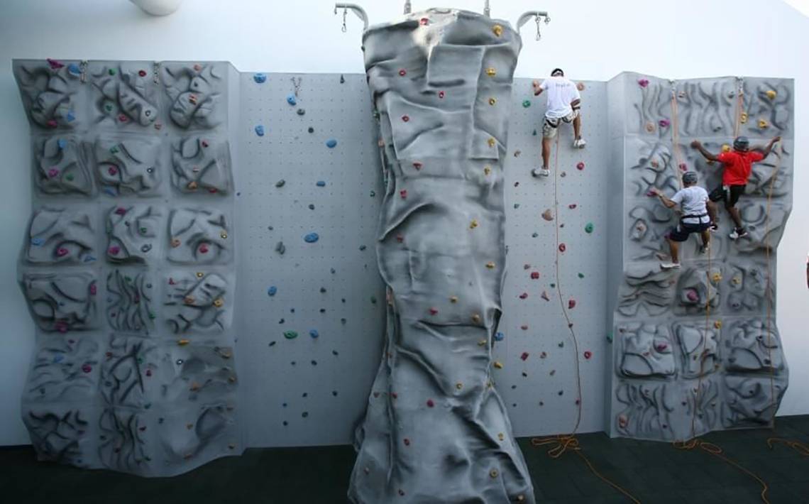 Foto von drei Personen, die an einer künstlichen Kletterwand im Jumeirah Beach Hotel klettern.