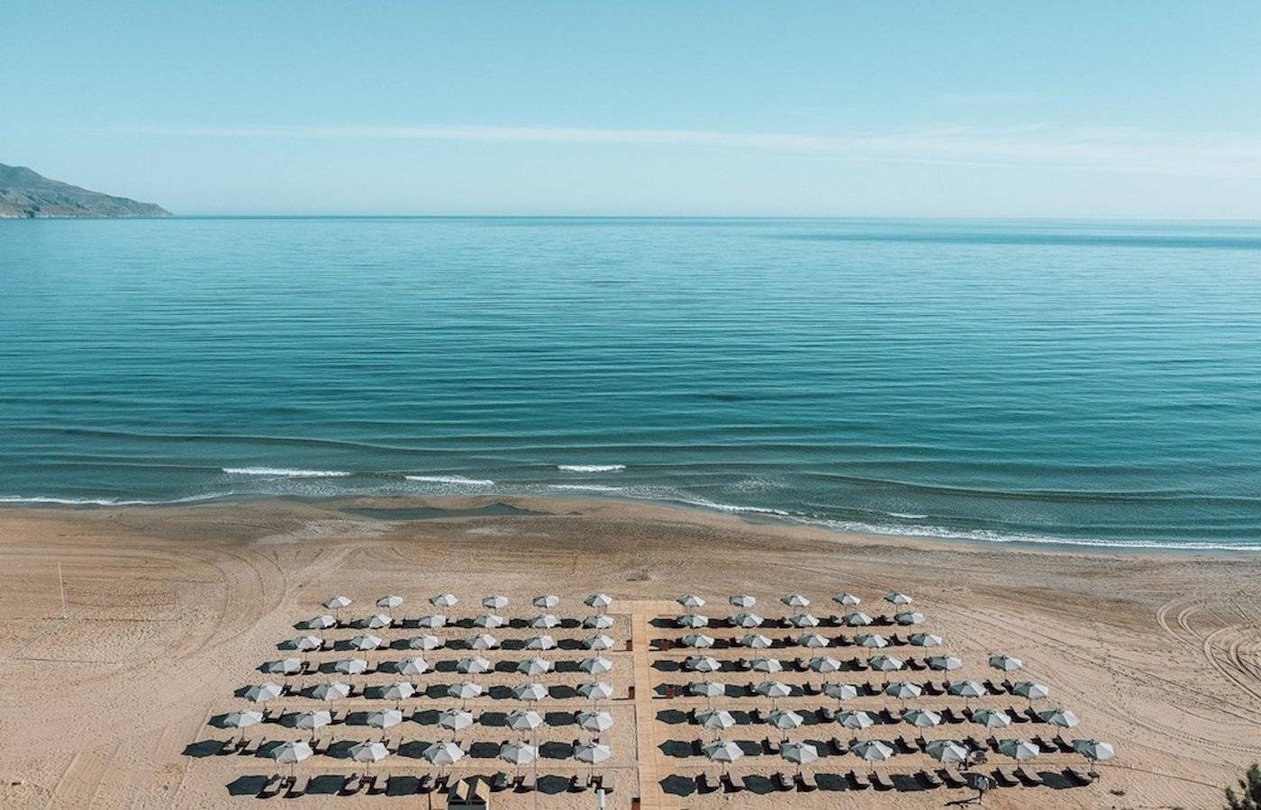 Luftaufnahme des Eliros Mare Hotels mit Sonnenschirmen auf dem Strand