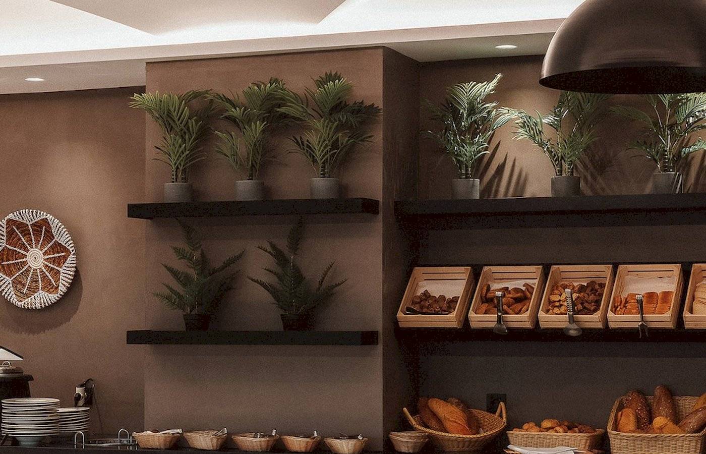 Frühstücksbuffet im Eliros Mare Hotel mit Brotkörben und Pflanzen.