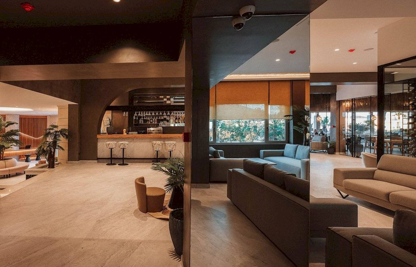 Innenbereich des Eliros Mare Hotels mit Bar, Sofas und Pflanzen.