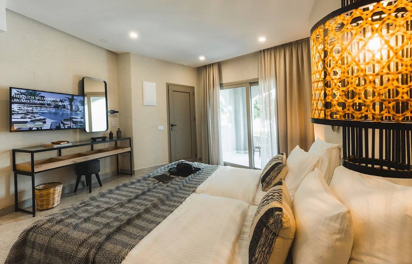 Schlafzimmer im Eliros Mare Hotel mit einem Doppelbett, Fernseher und Schreibtisch.