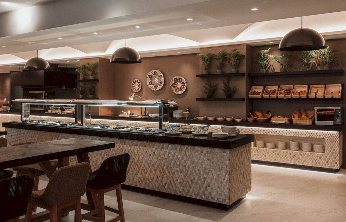 Frühstücksbuffet im Eliros Mare Hotel mit Tisch, Stühlen, Pflanzen und Speisen