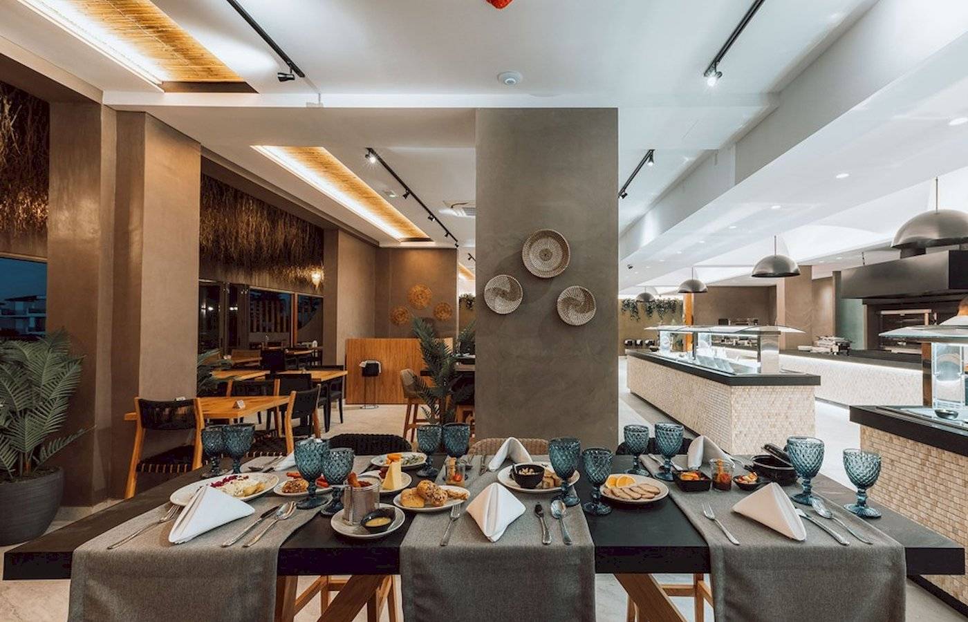 Frühstücksbuffet im Eliros Mare Hotel mit verschiedenen Gerichten und Geschirr.