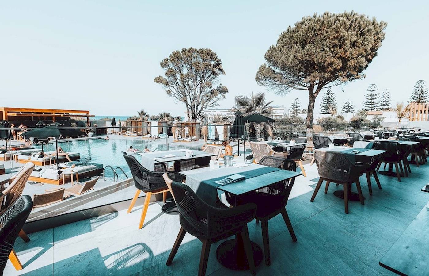 Terrasse des Eliros Mare Hotels mit Tischen, Stühlen und Blick auf den Pool
