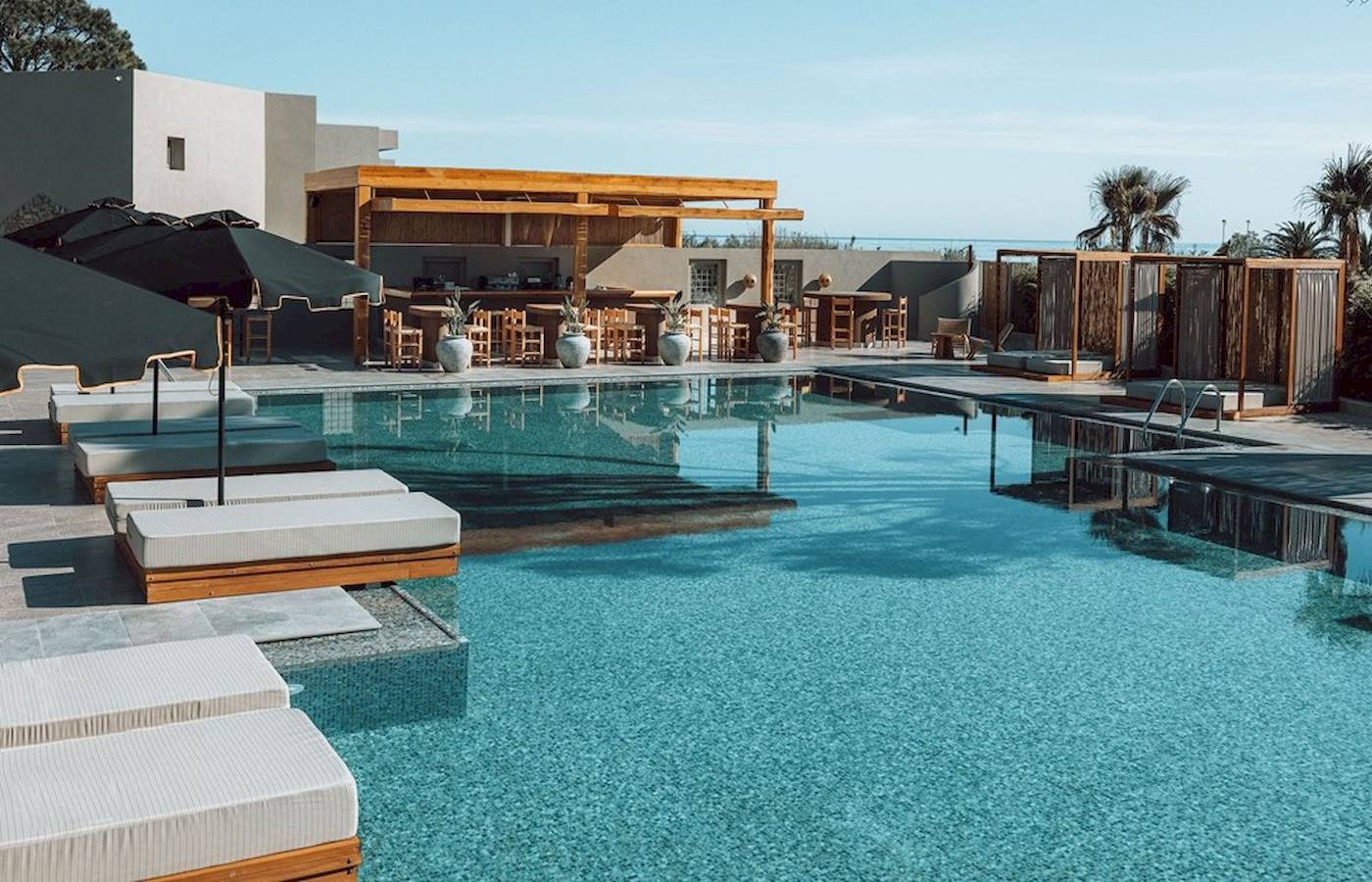 Außenbereich des Eliros Mare Hotels mit Pool, Lounge-Bereich und Bar.