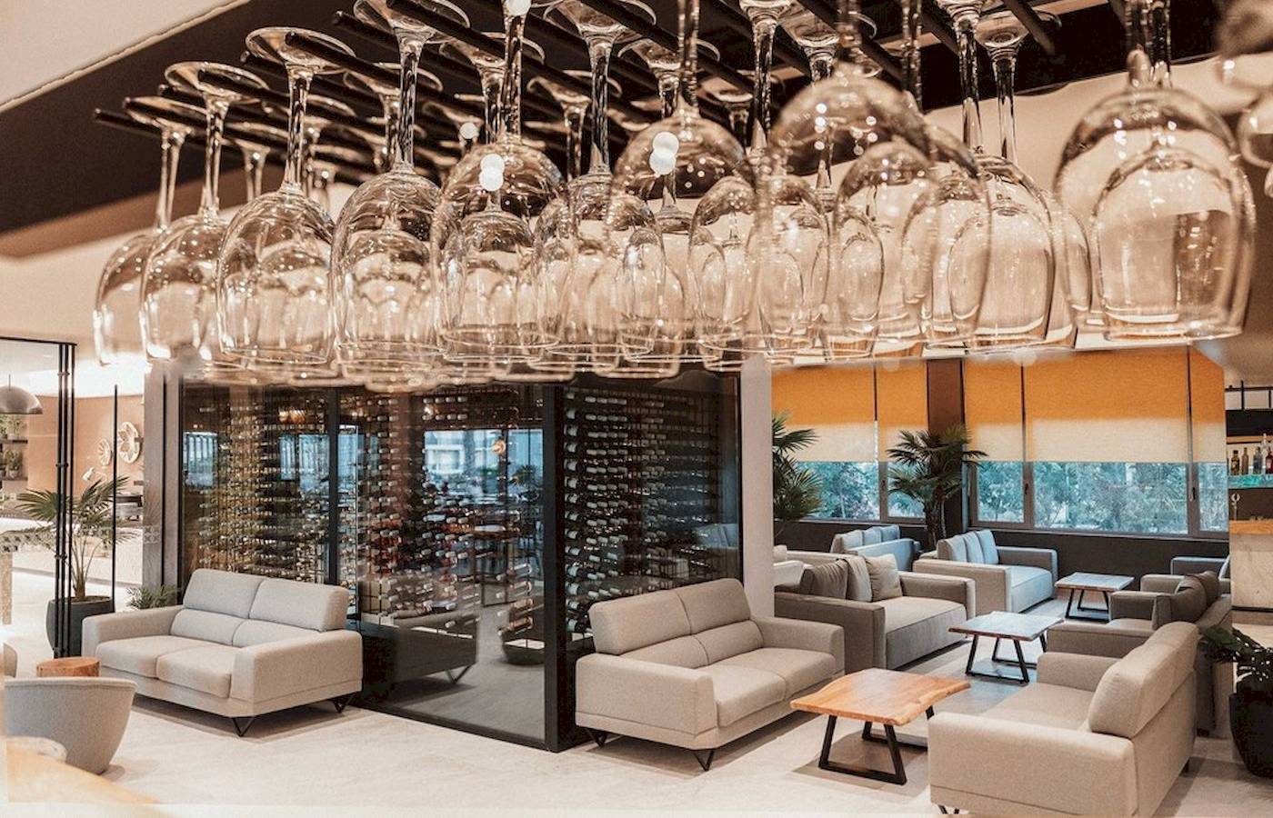 Loungebereich des Eliros Mare Hotels mit hängenden Weingläsern und Sofas.