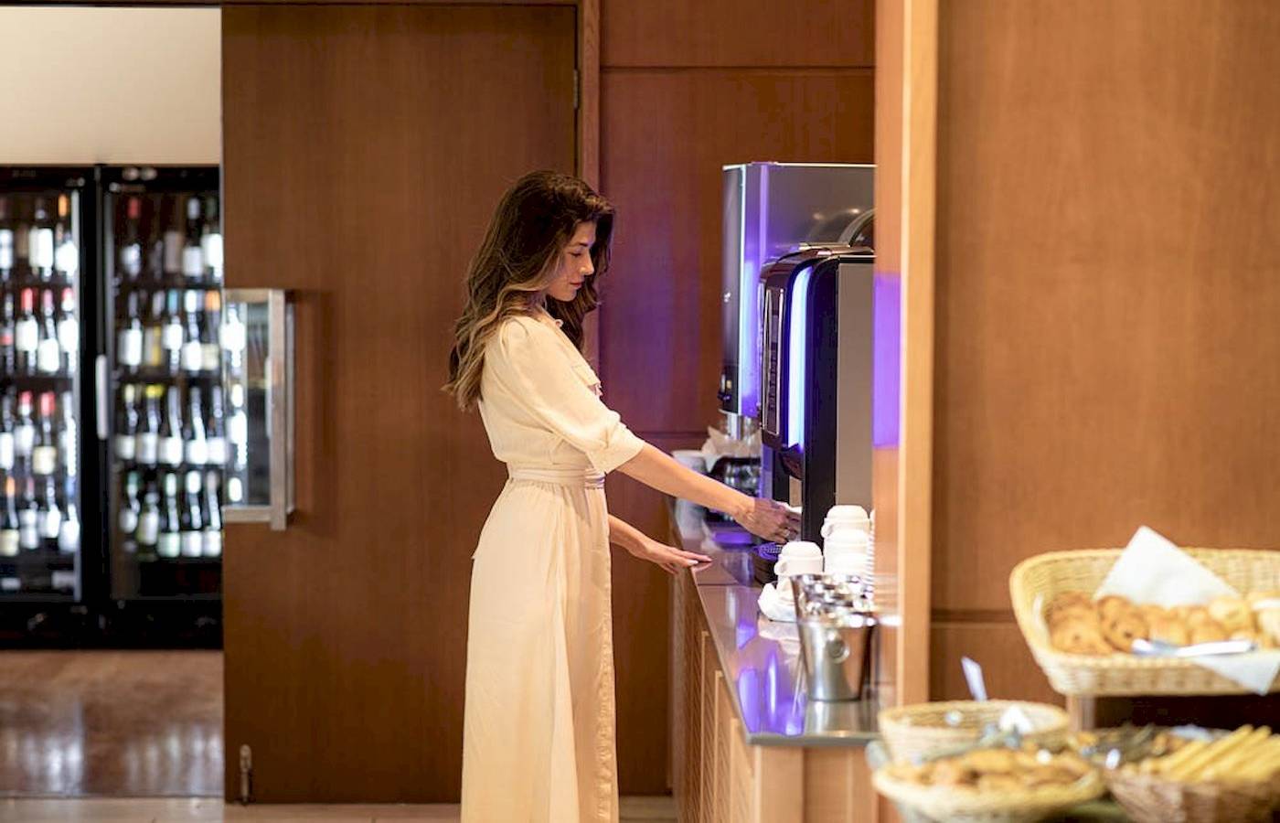 Frau am Kaffeeautomaten im Hotel Cretan Dream Resort & Spa