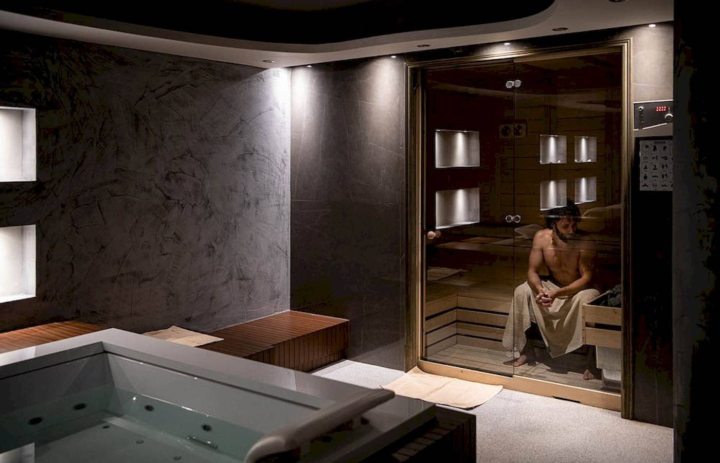 Ein Saunabereich im Cretan Dream Resort & Spa mit einem Mann, der in der Sauna sitzt.