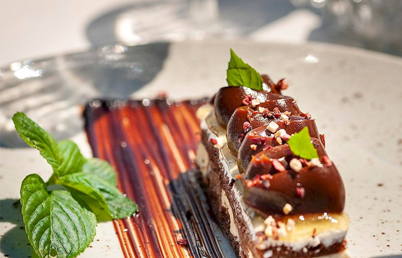 Stück Nachtisch im Cretan Dream Resort & Spa mit Schokoglasur und Minzblättern.