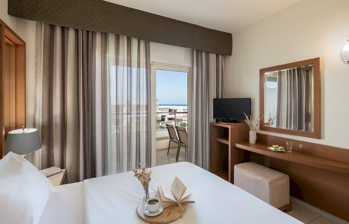 Innenansicht eines Hotelzimmers im Cretan Dream Resort & Spa mit Blick auf das Meer.