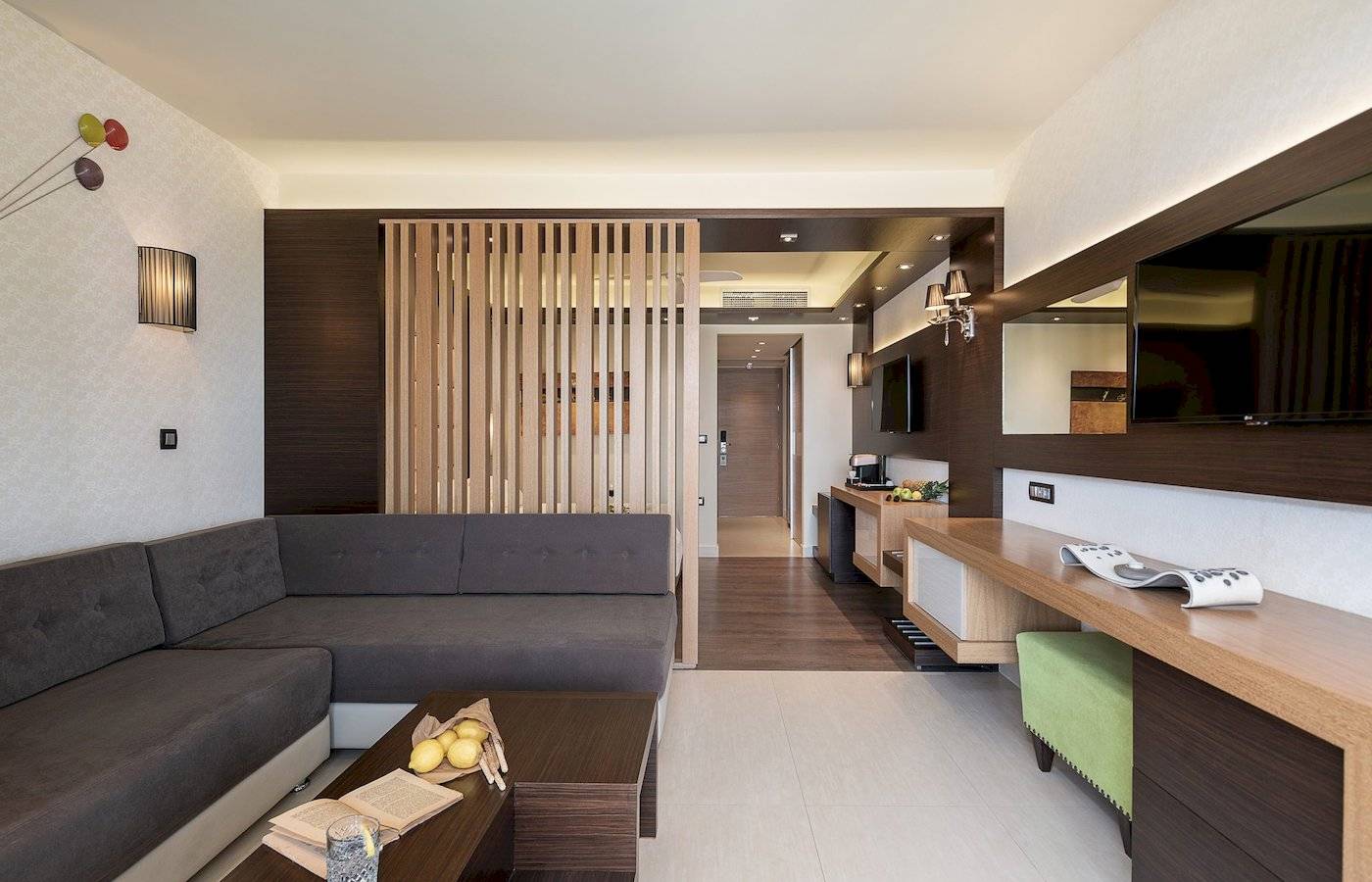 Inneneinrichtung des Cretan Dream Resort & Spa mit Sofa, Couchtisch, Büchern und Fernseher.