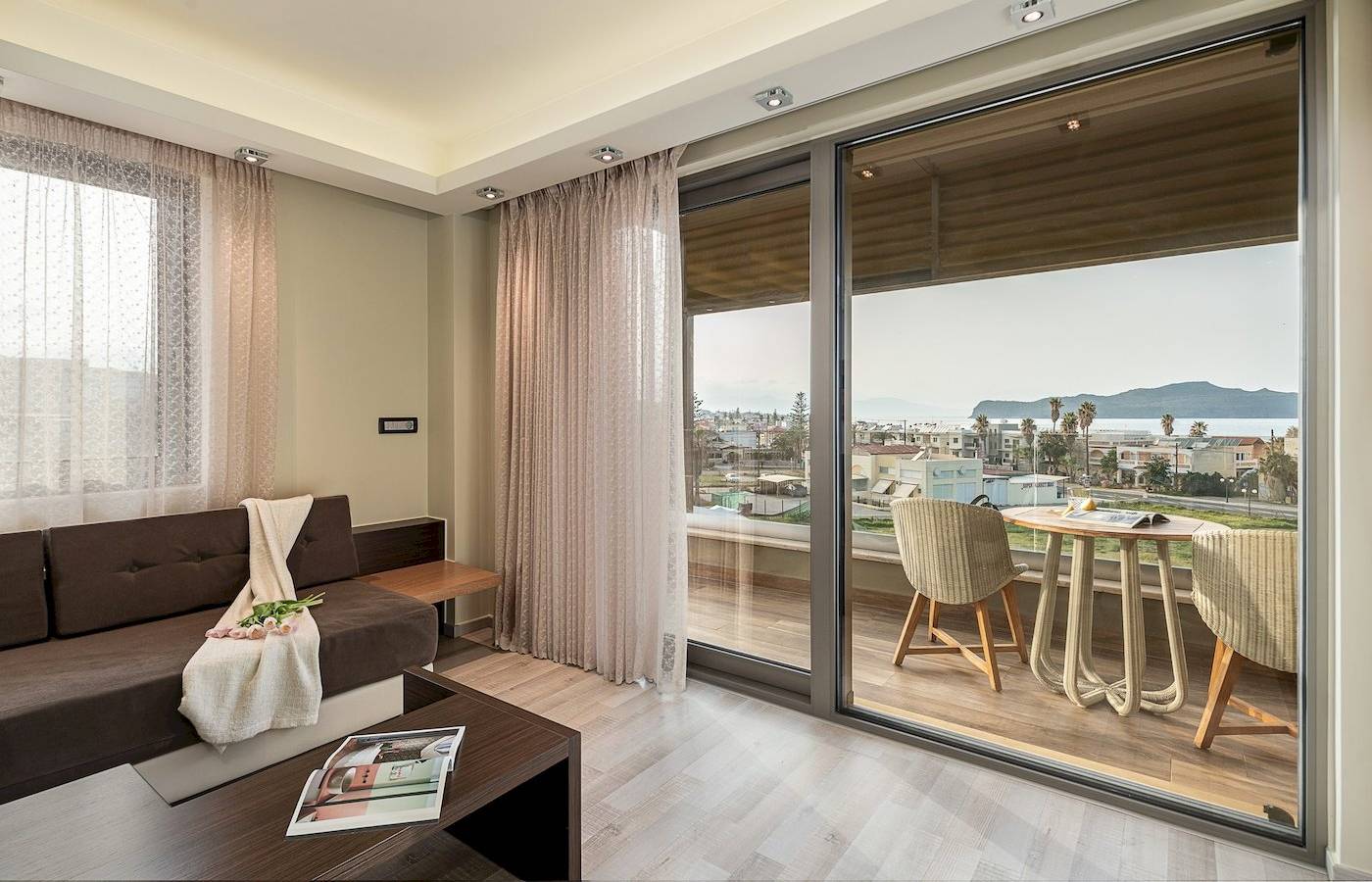 Wohnzimmer des Cretan Dream Resorts & Spa mit Meerblick, inklusive Sofa, Tisch und Panoramafenstern.