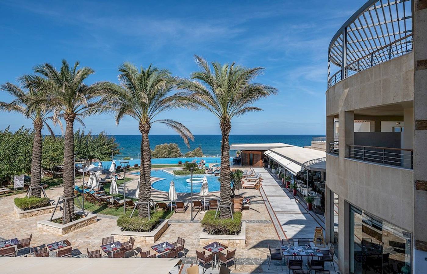 Außenansicht des Cretan Dream Resort & Spa mit Swimmingpool und Meer im Hintergrund.