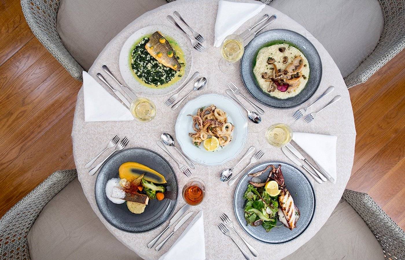 Foto von mehreren Tellern mit Gerichten auf einem Tisch im Cretan Dream Resort & Spa.