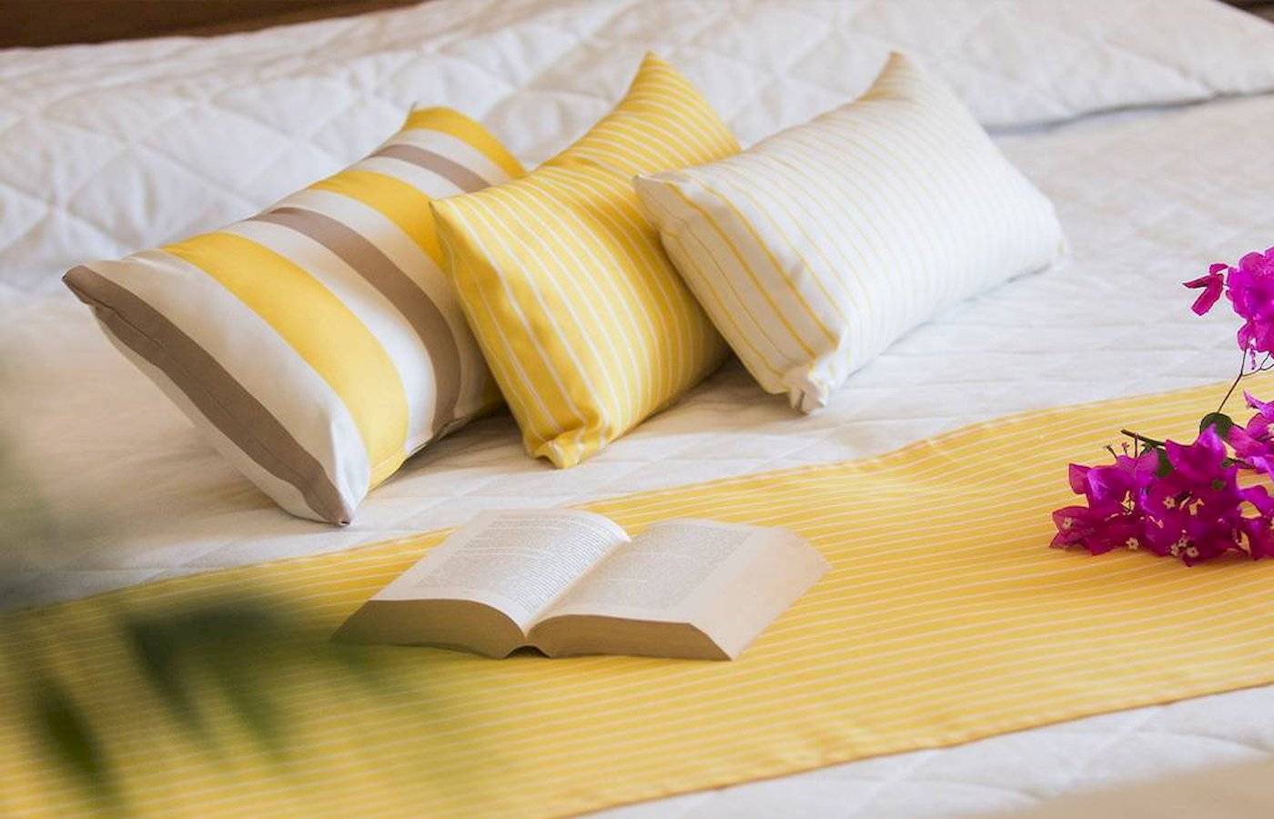 Hotelbett mit Kissen und Büchern von Chrissi Amoudia