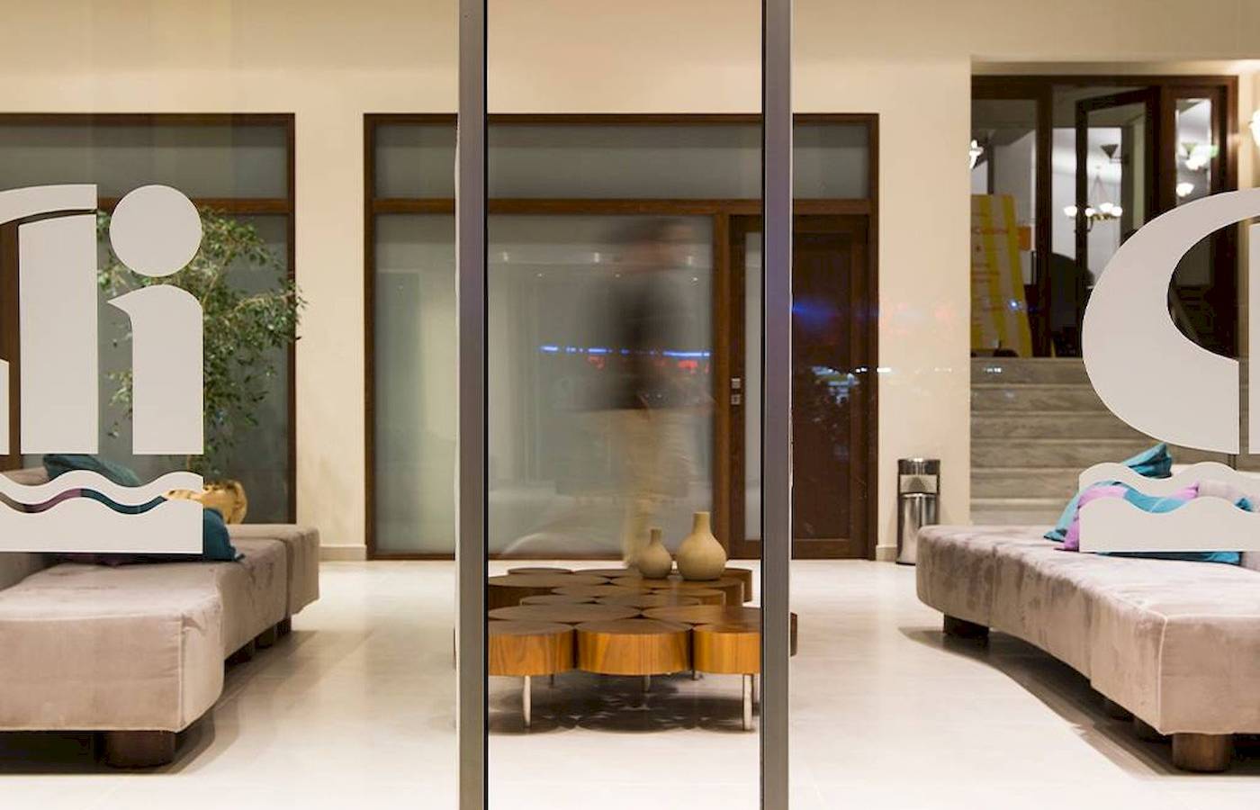 Lobby des Chrissi Amoudia Hotels mit modernen Möbeln und einem zentralen Tisch.