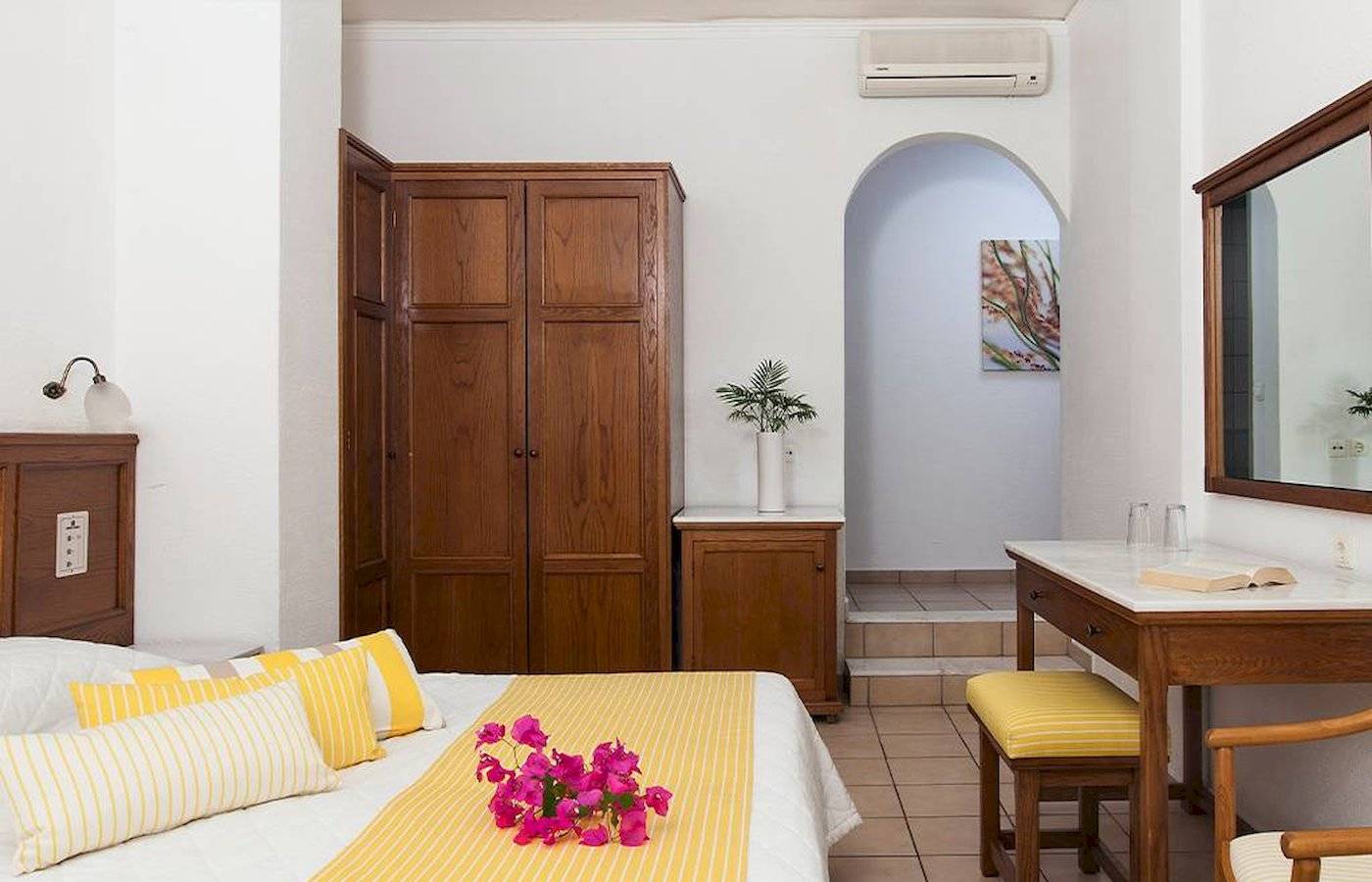 Innenansicht eines Zimmers im Chrissi Amoudia Hotel mit Bett, Dekor und Möbeln.