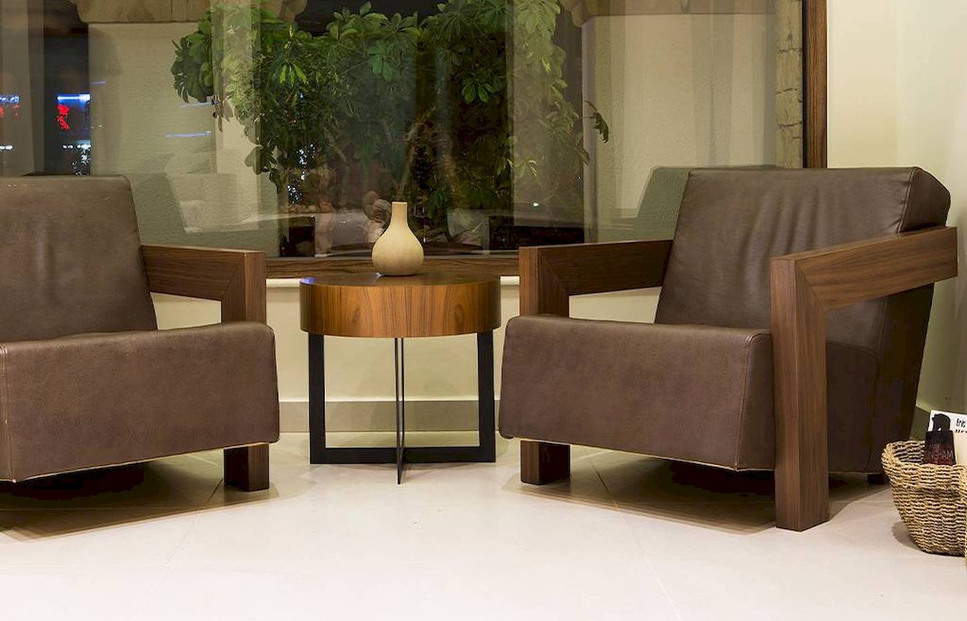 Loungebereich im Chrissi Amoudia Hotel mit zwei Ledersesseln und einem Tisch.