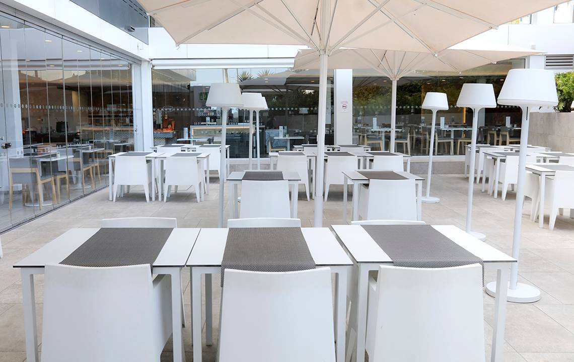 Außenbereich des LABRANDA Bronze Playa Restaurants mit weißen Tischen und Stühlen unter Schirmen.
