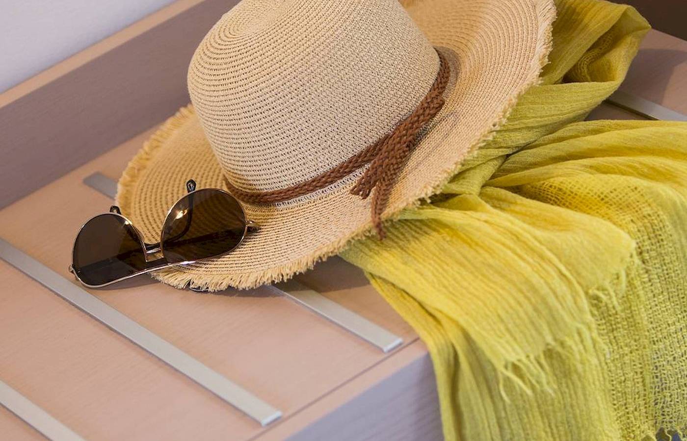 Sommer-Accessoire wie Hut und Sonnenbrille auf einem Tisch im Hotel Chrissi Amoudia
