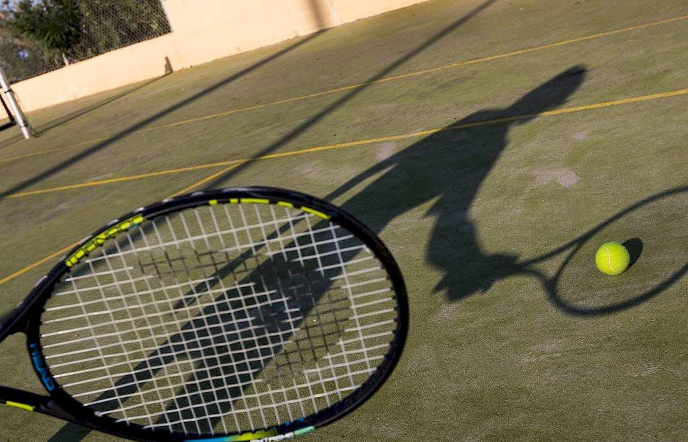 Tennisschläger mit Tennisball auf einem Tennisplatz.