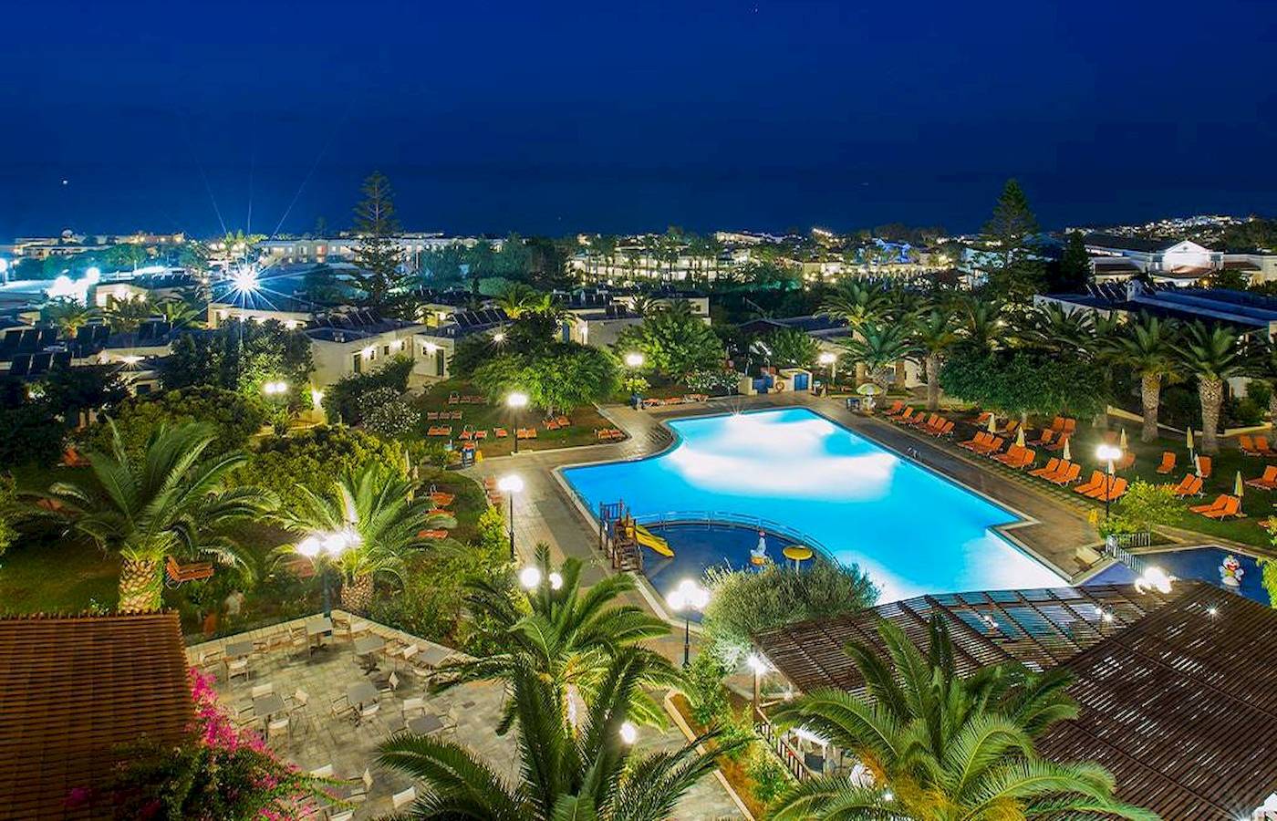 Abendliche Ansicht des Chrissi Amoudia Hotels mit Swimmingpool und Sonnenliegen