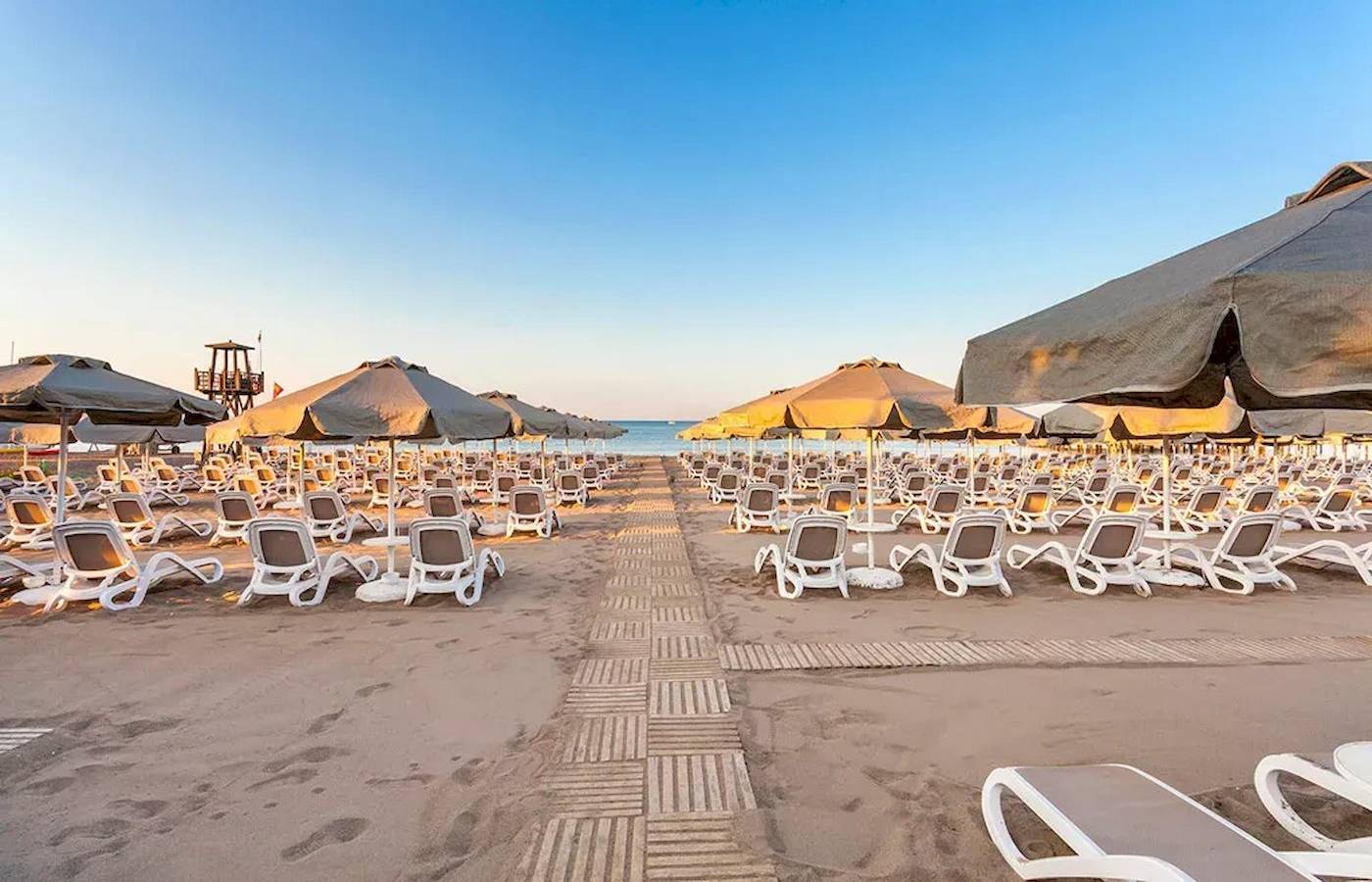 Strand des Melas Lara Hotels mit vielen Sonnenliegen und Sonnenschirmen