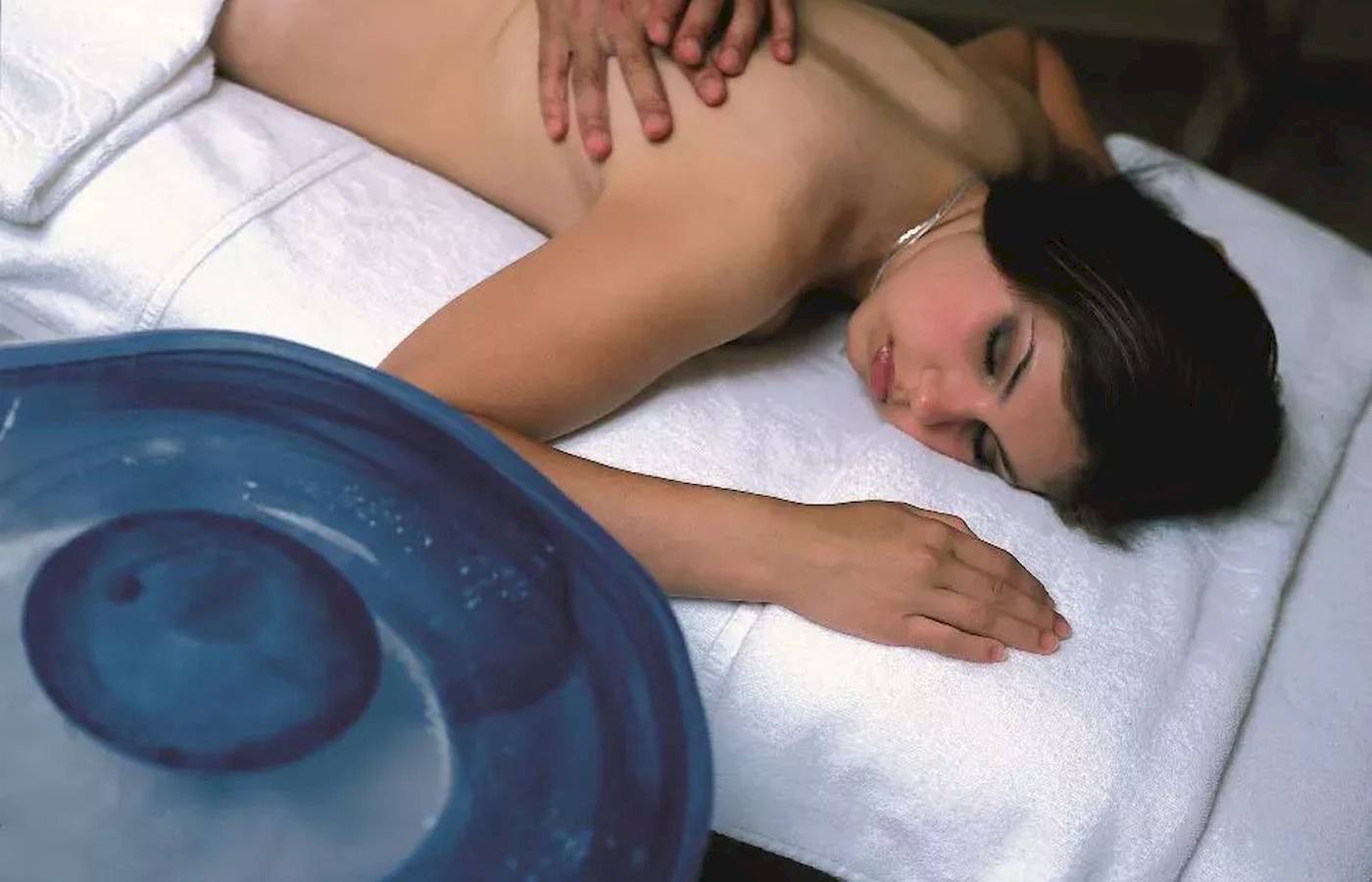 Eine Frau liegt im Melas Lara Hotel auf einem Massagetisch und erhält eine Massage.