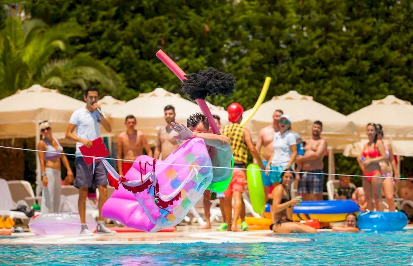 Pool-Party-Animation im Melas Lara Hotel mit einem Mann, der über eine aufblasbare Matratze springt.