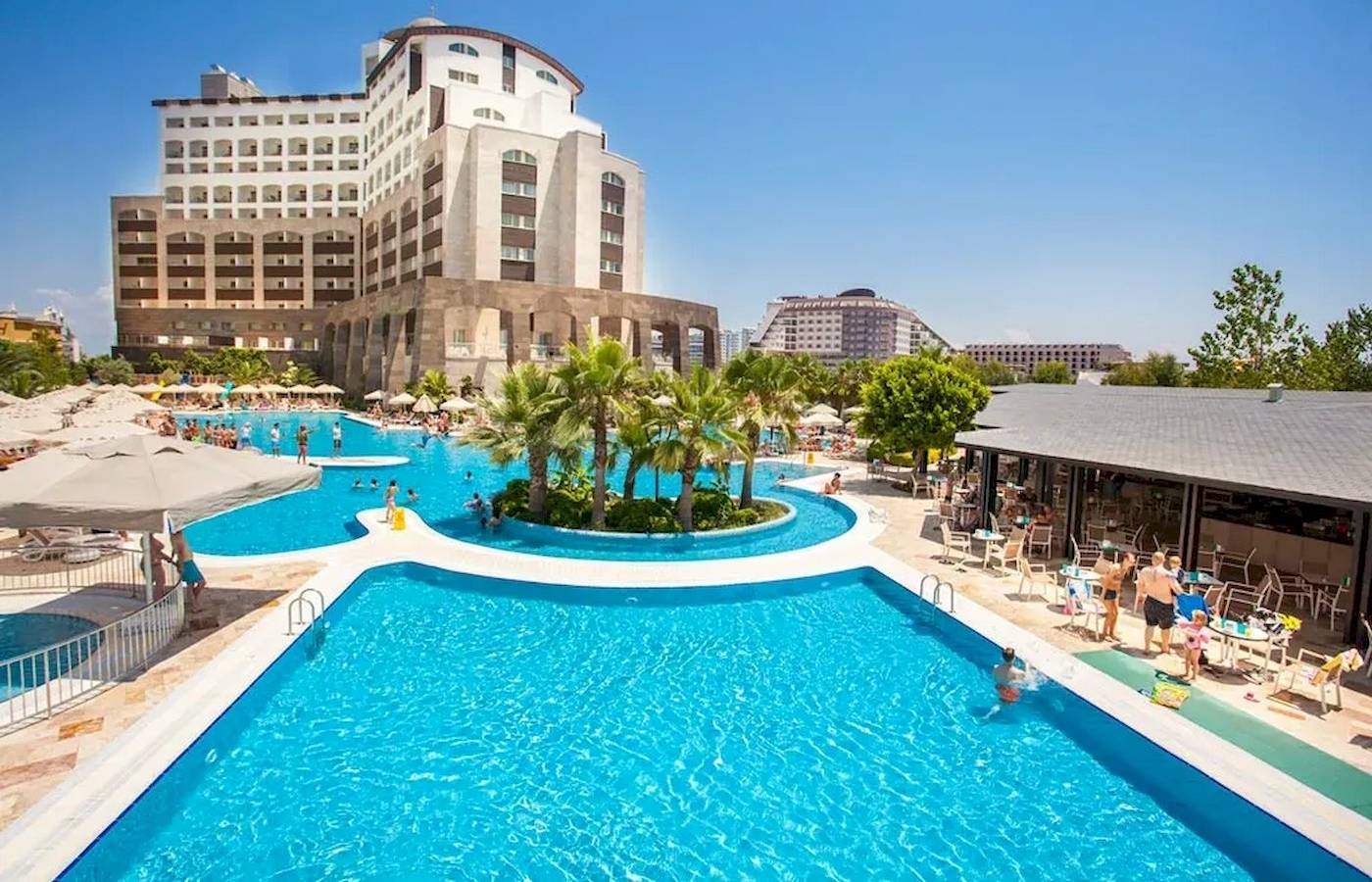 Außenbereich des Melas Lara Hotels mit Swimmingpool und vielen Gästen