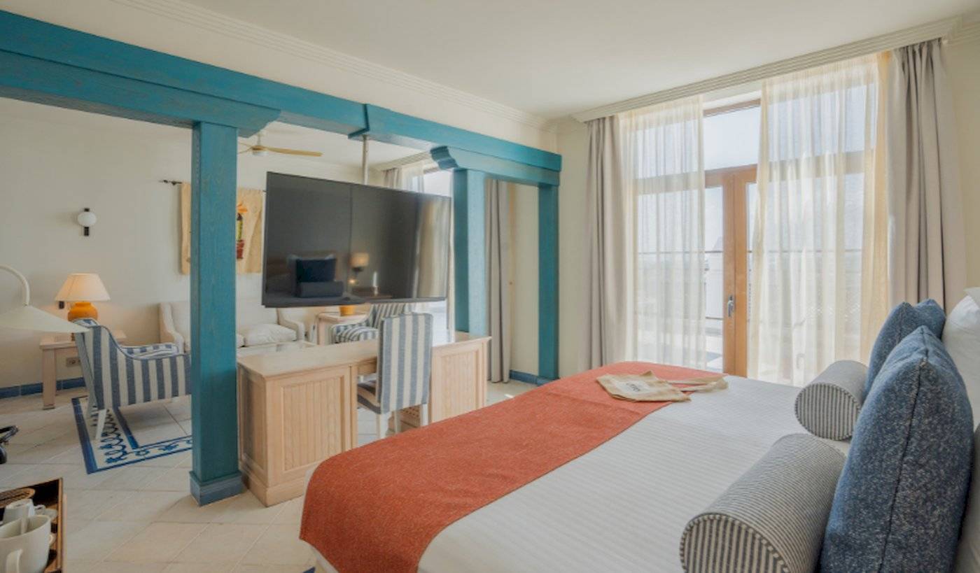 Innenansicht eines Zimmers im LIVVO Volcan Lanzarote Hotel mit einem großen Bett, Fernseher und Schreibtisch.