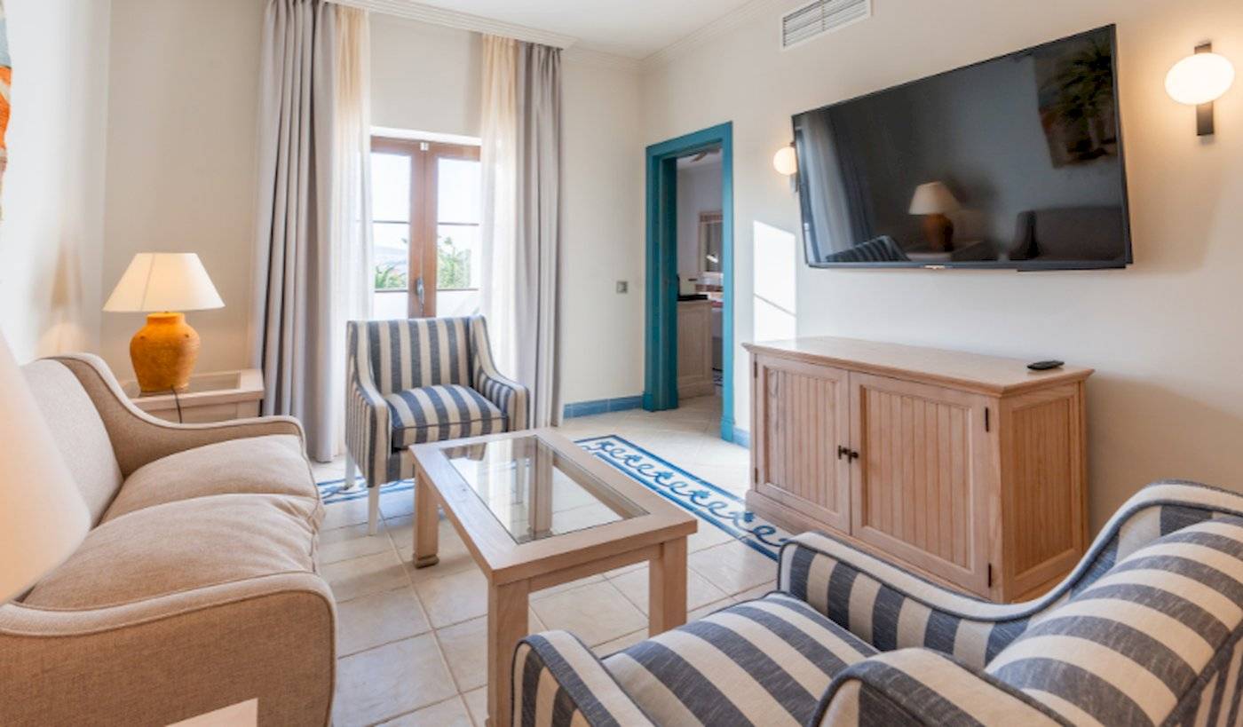 Wohnzimmer im LIVVO Volcan Lanzarote Hotel mit Fernseher, Couch, Stühlen und Tisch