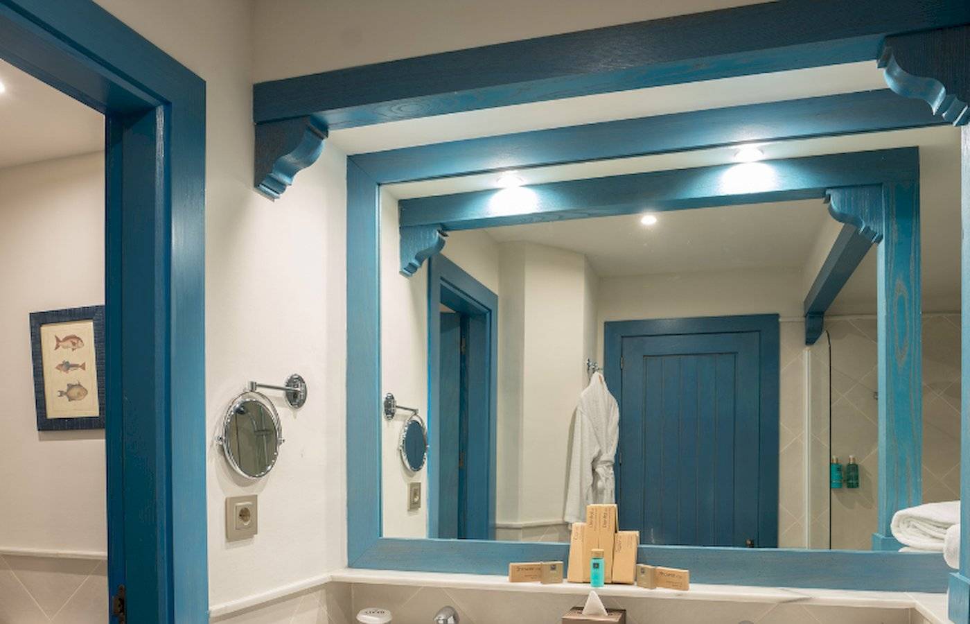 Badezimmer im LIVVO Volcan Lanzarote Hotel mit blauen Akzenten und einem Spiegel.