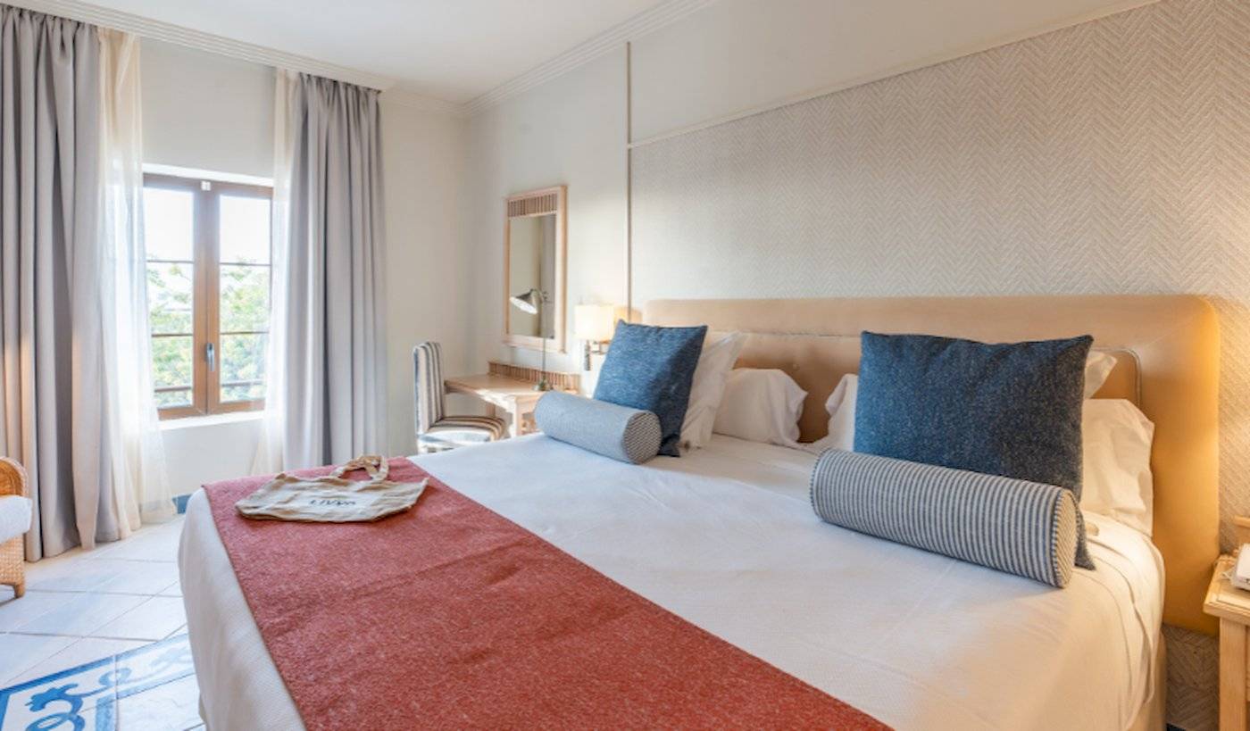 Ein elegantes Hotelzimmer im LIVVO Volcan Lanzarote mit einem Bett, Kissen und einem Schreibtisch.