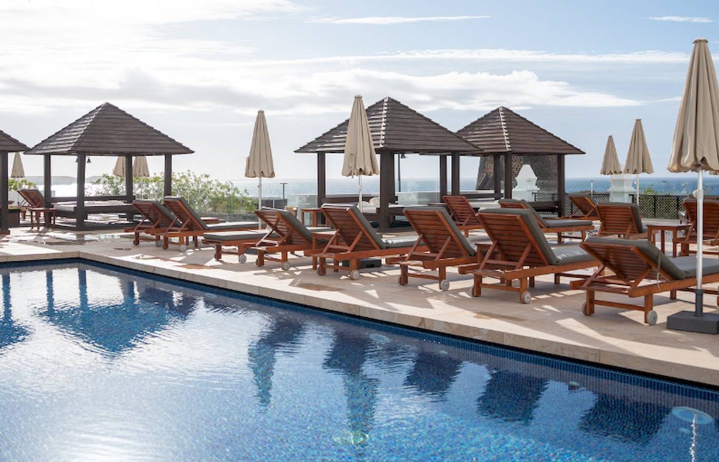 Pool-Terrasse des LIVVO Volcan Lanzarote Hotels mit Sonnenliegen und Schirmen