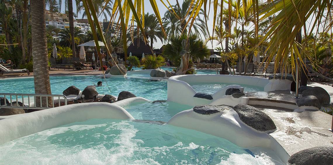 Außenpool mit Wasserrutschen und Felsen am Corallium Beach von Lopesan Hotels