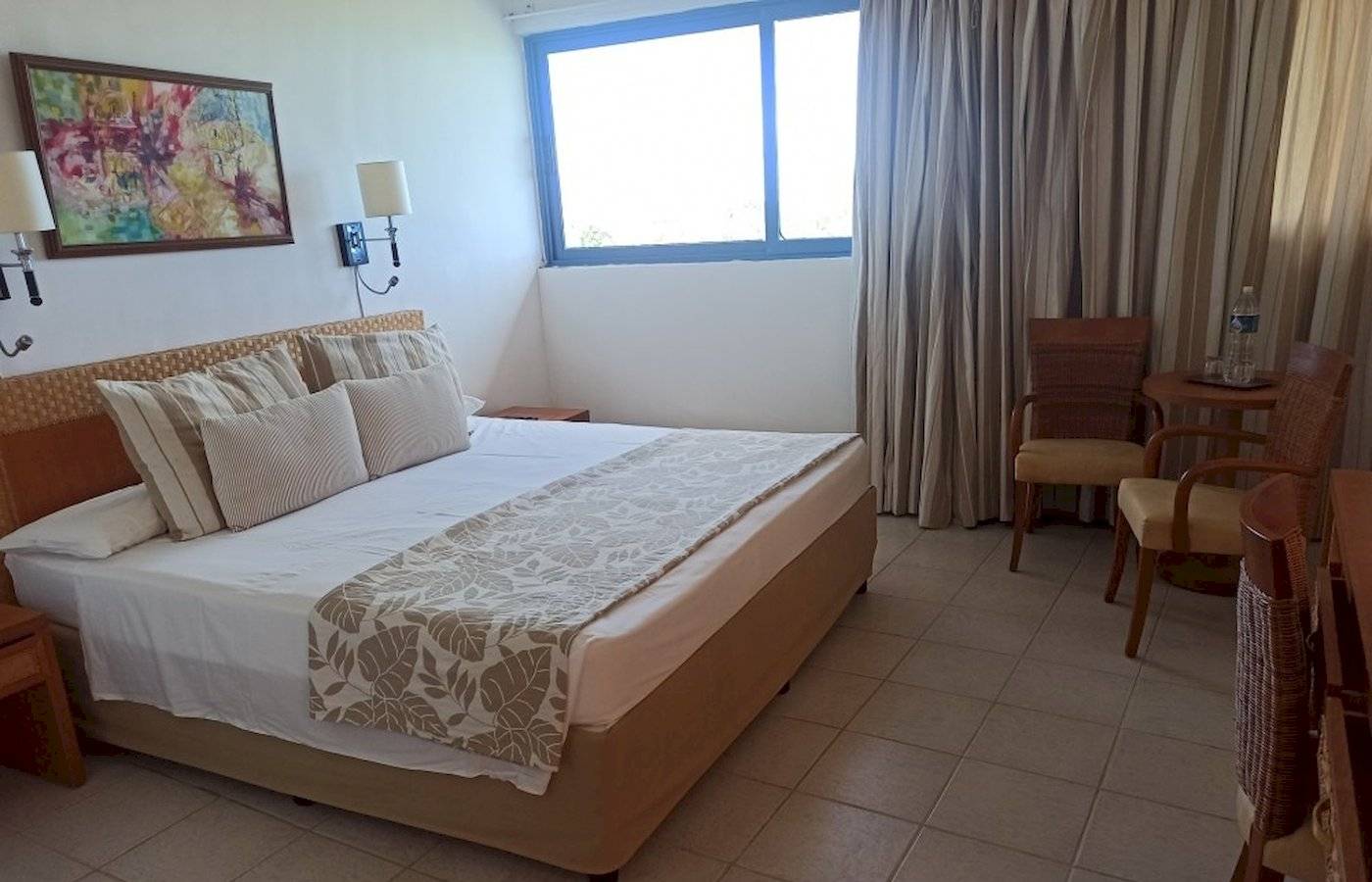 Hotelzimmer im Muthu Playa Varadero mit Bett, Fenster, Gemälde und Möbeln.
