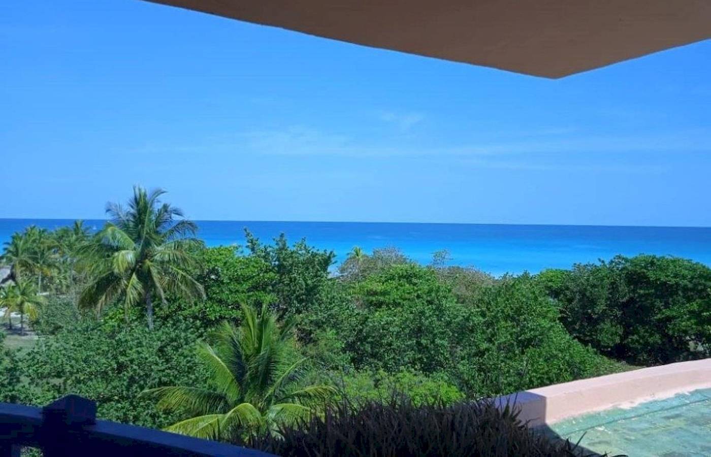 Aussicht auf den Ozean vom Muthu Playa Varadero Hotel aus mit blauem Himmel und grüner Vegetation.