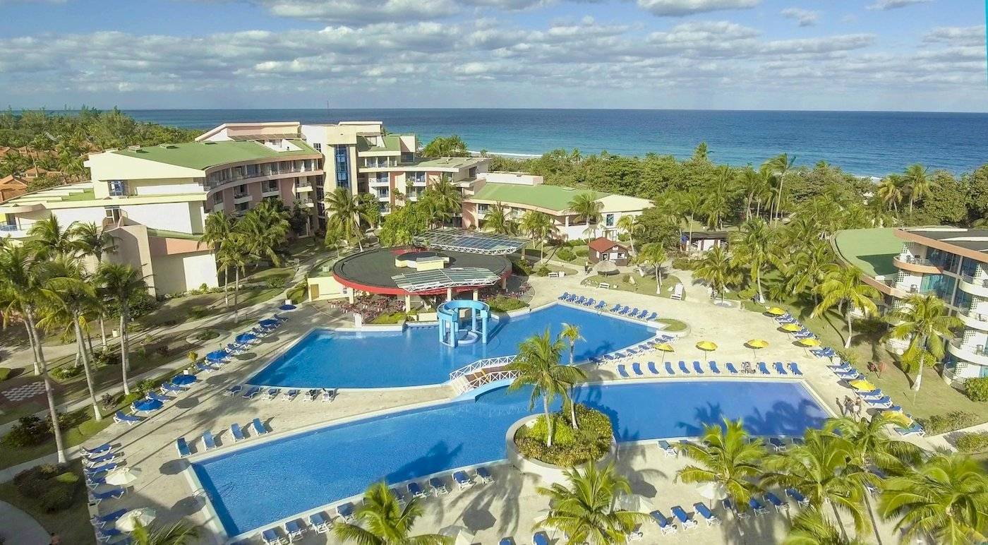 Luftaufnahme des Muthu Playa Varadero Hotels mit großen Swimmingpools und Sonnenliegen.