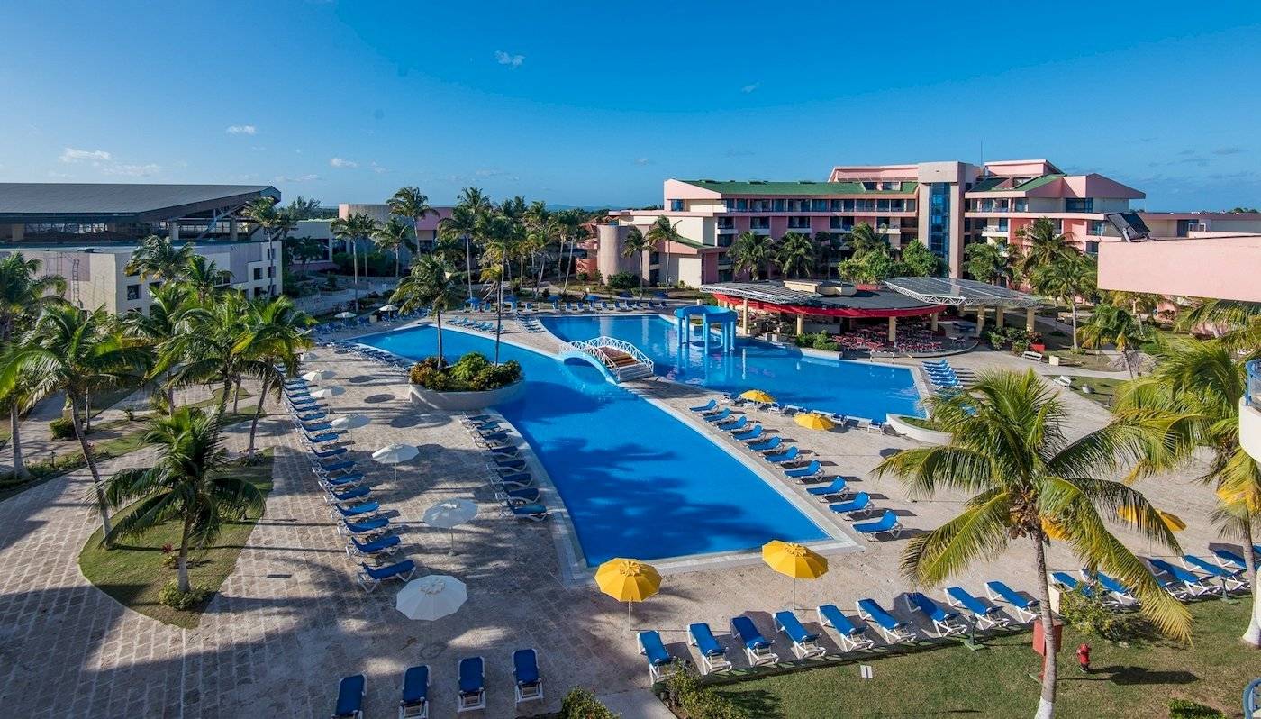 Muthu Playa Varadero Hotel mit großem Pool und vielen Liegestühlen und Palmen.
