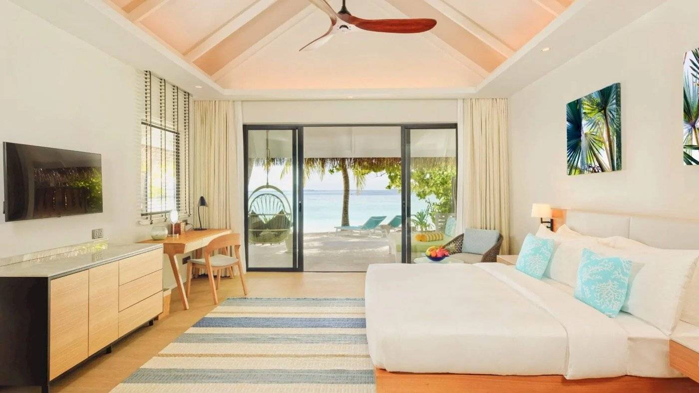 Ein Schlafzimmer im Nova Maldives Hotel mit Blick auf das Meer und eine Terrasse.