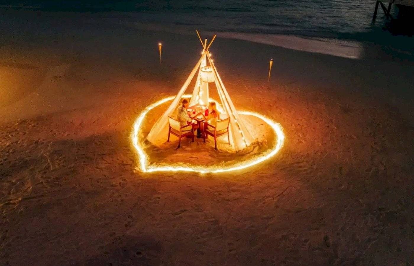 Ein romantisches Abendessen für zwei Personen in einer runden Zelt auf dem Strand des Nova Maldives