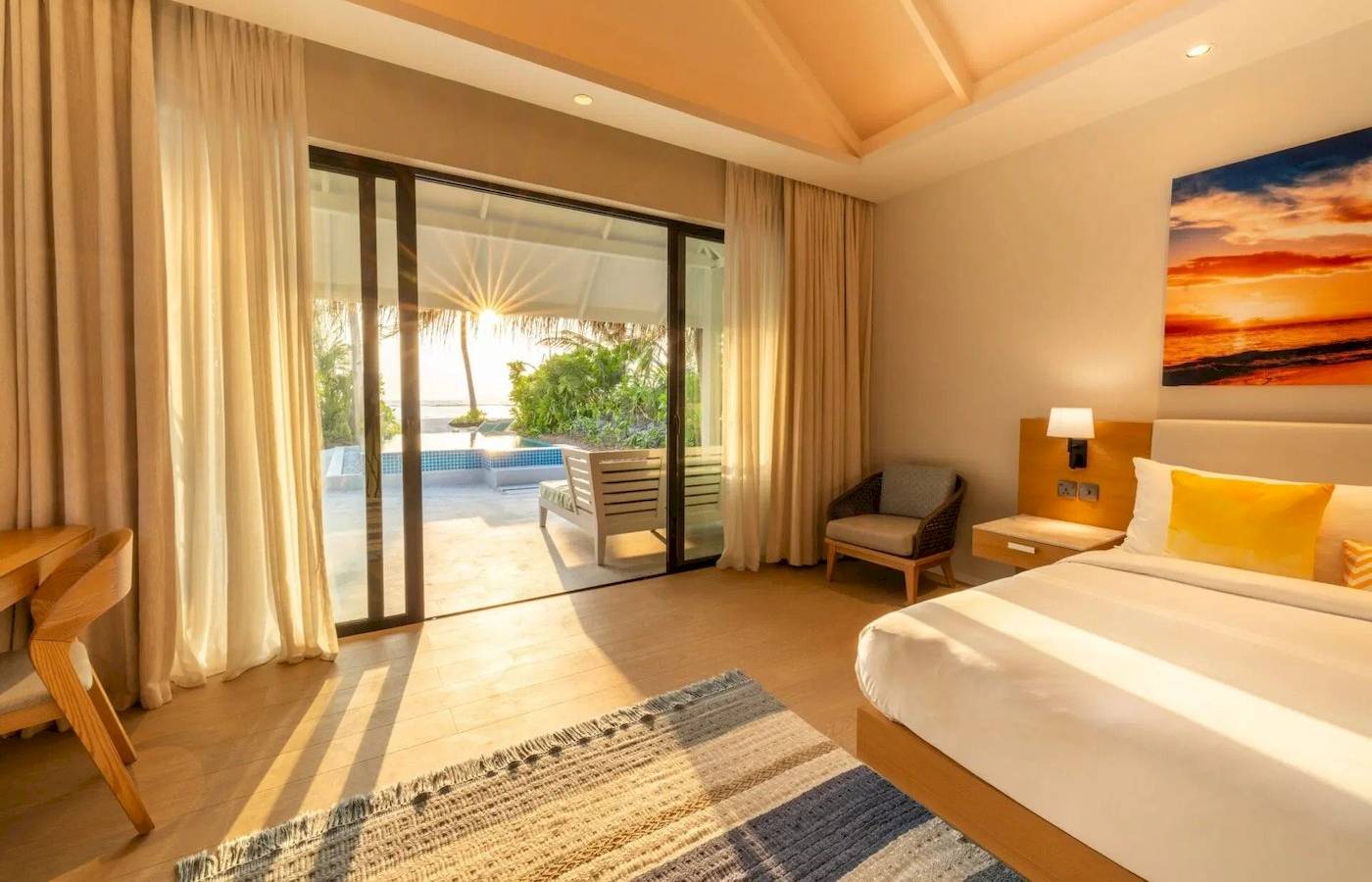 Suite-Zimmer im Nova Maldives Hotel mit Aussicht auf einen Pool und Meer.